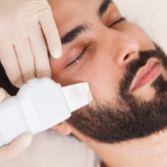Male client receives ultrasonic exfoliation
