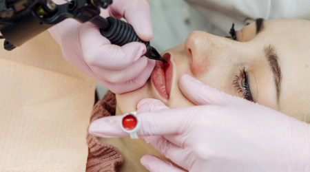woman tattoos lips of her client